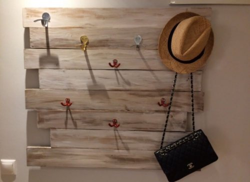 A hat and a purse hanging from a perch.