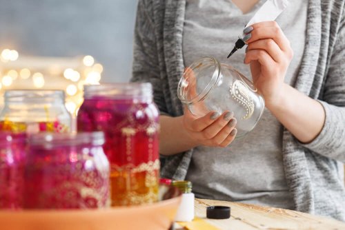 A woman painting jars.