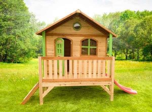 A wooden playhouse with slide and patio.