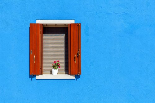 Rustic shutters in a blue facade.