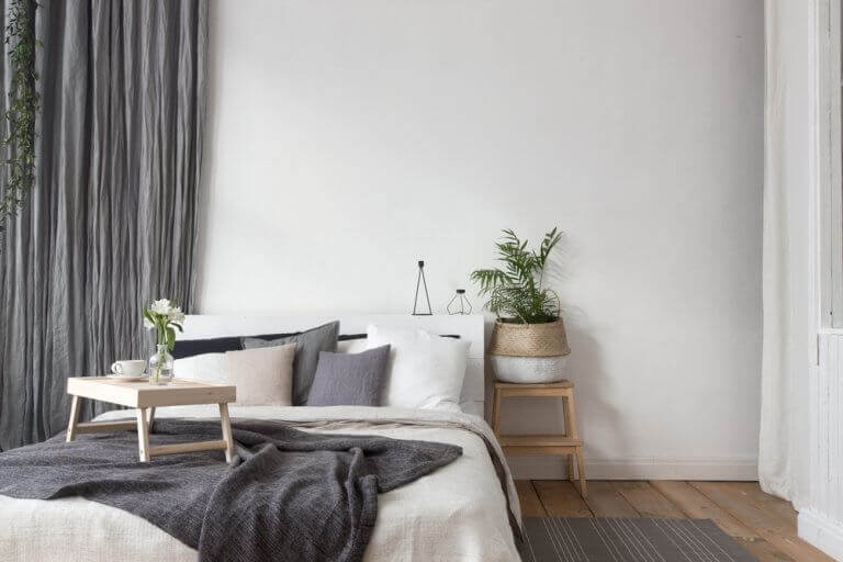 Use of gray textiles and natural wood in a bedroom
