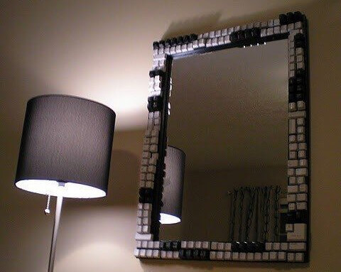 A mirror frame decorated with black and white keyboard keys.