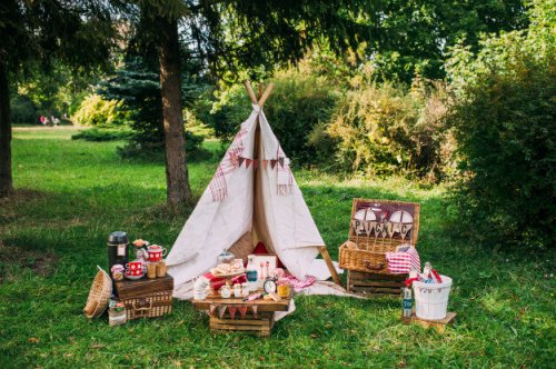 Decorating a picnic in an intimate way is possible. In this picture, a teepee and wicker baskets set up for a romantic picnic.