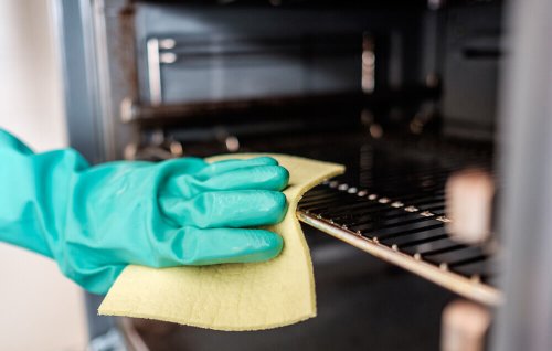 A person cleaning rust stains from an oven.