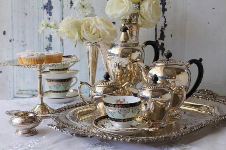 A typical English afternoon tea complete with gold service, fine china and cupcakes