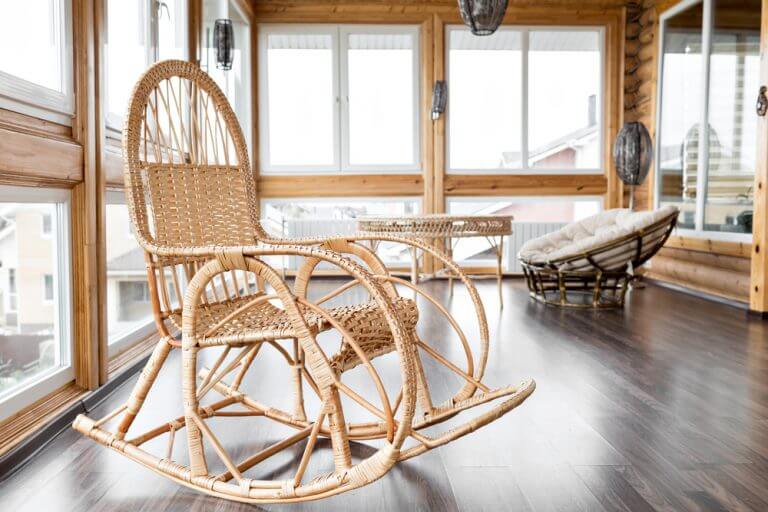 A traditional wicker rocker in an enclosed patio