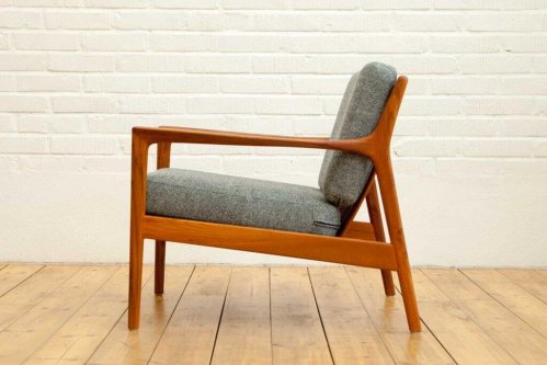A chair with grey upholstry designed by Folke Olhsson.