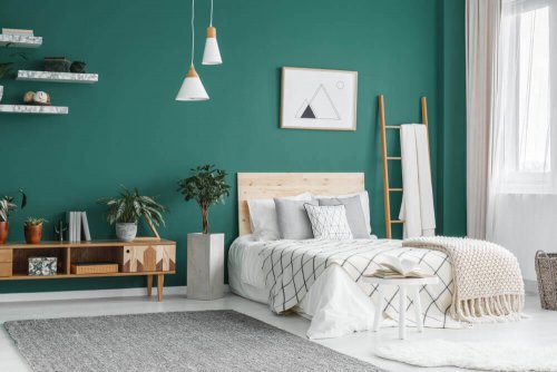 A bedroom with an emerald green wall