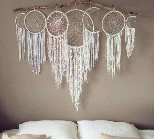 Seven dreamcatchers above a bed.