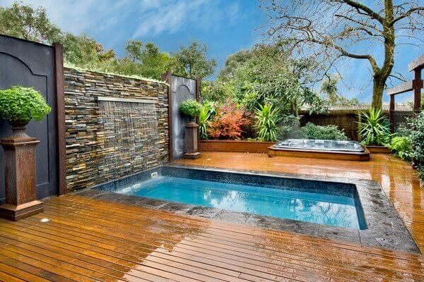 A backyard immersion pool with a waterfall decoration