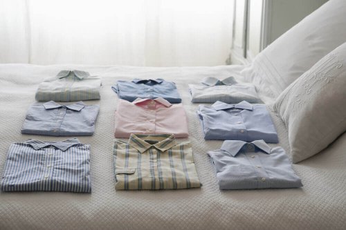 Folded shirts on a bed.