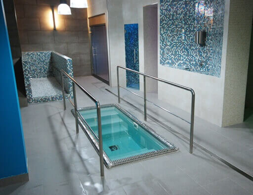 An indoor immersion pool with railing