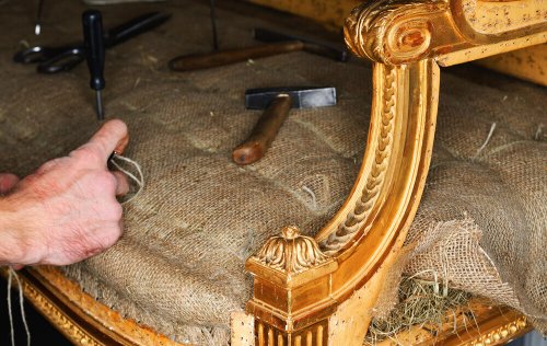 A person repairing a sofa.