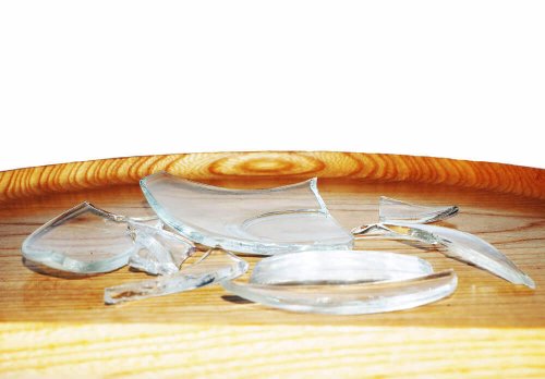 Pieces of broken glass on a wooden table.
