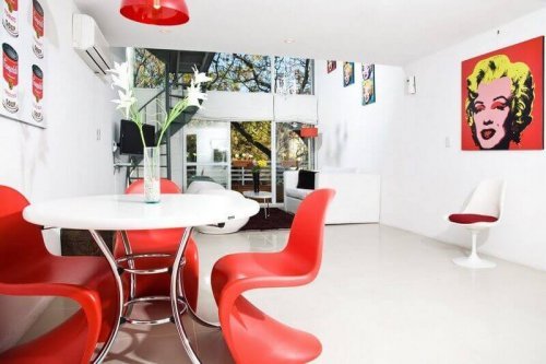 Orange molded chairs at a white table pop style