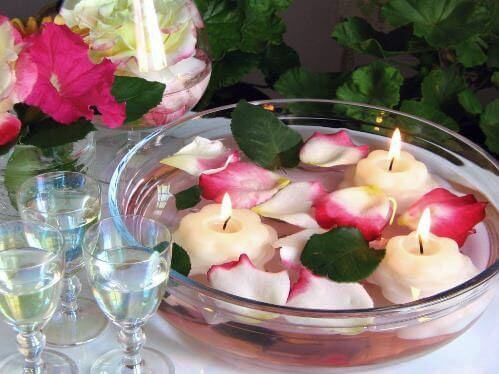 A rose petal and candle centerpiece.