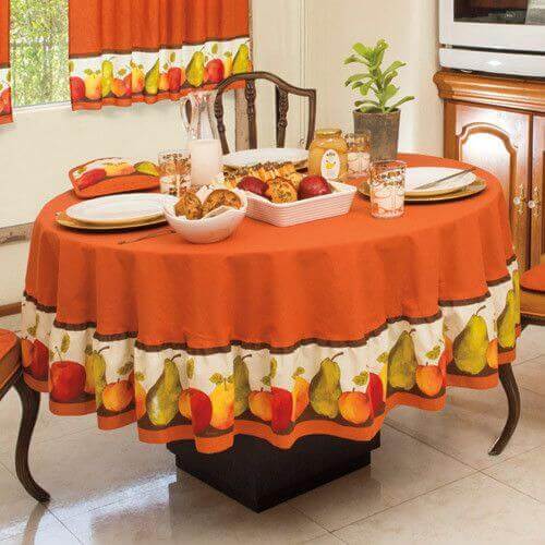 Table set with a festive tablecloth with a fruit design