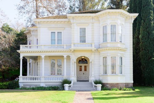 A two-story white Victorian house.
