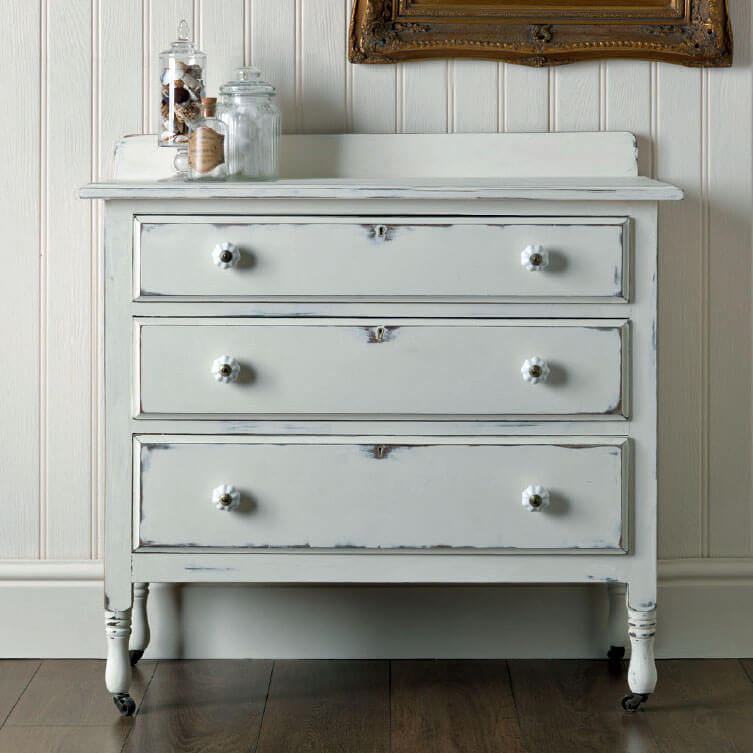 A vintage dresser painted white.