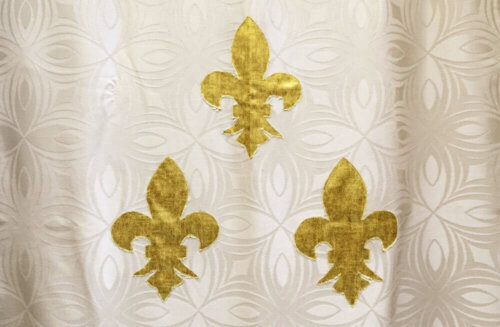 A curtain with a fleur de Lis motif.