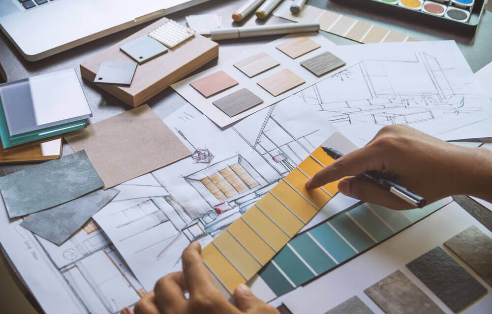 An architect works on a blueprint for house renovations.
