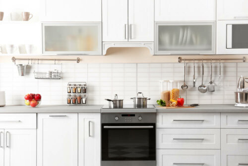 A white kitchen with handles on the cabinets.