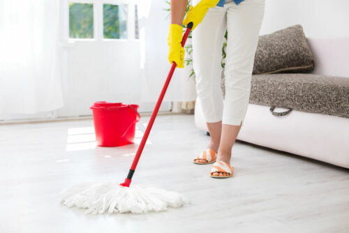 A woman mopping the floor.
