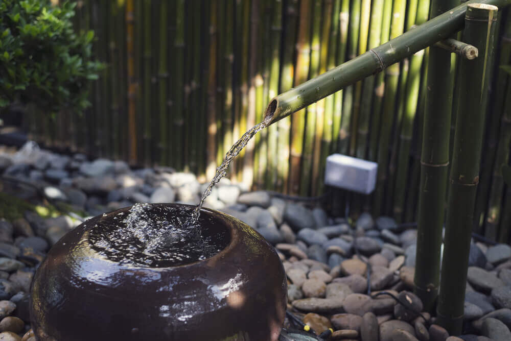 A zen fountain in a garden.