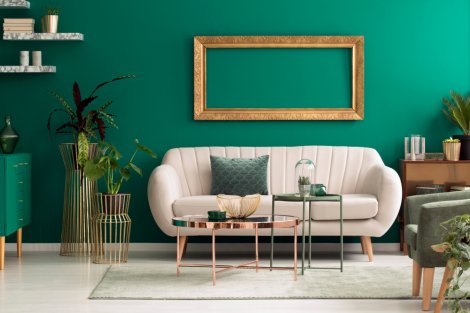 A beige sofa in contrast against a green wall