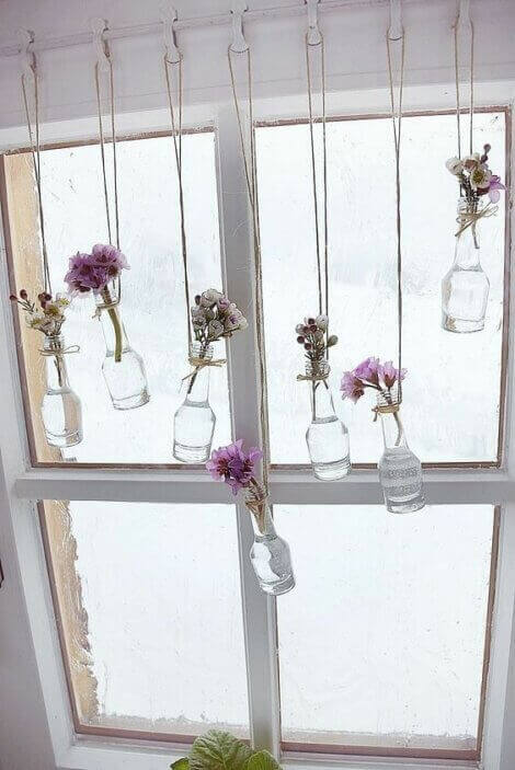 Using glass bottles as flower vases to decorate the window