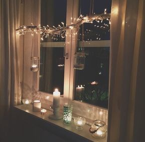 Using candles and fairy lights to decorate the inside of a window