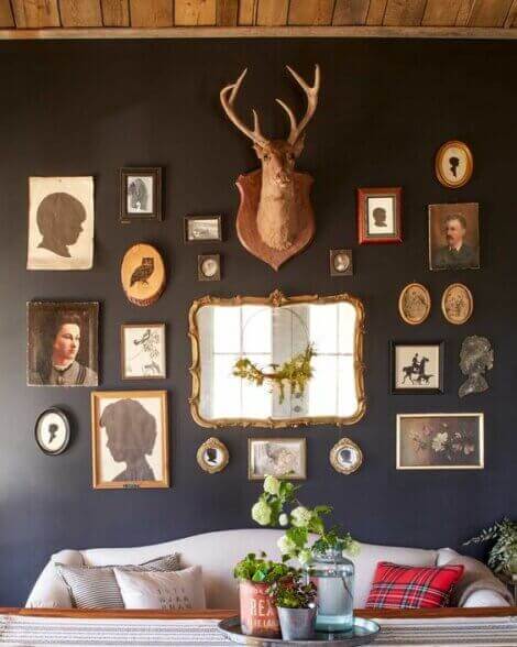 A collage of mirrors, portraits, deer heads and other elements of hunting home decor