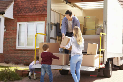 A family putting boxes in a moving truck.
