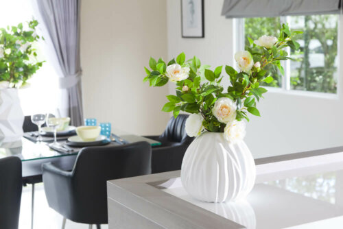 A white vase with a plant in the living room.
