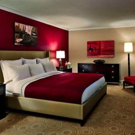 Using table and floor lamps to create a warm atmosphere in a red themed bedroom