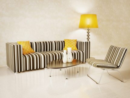 A striped black and white sofa with yellow accents is the perfect contrast in a plain room