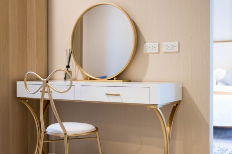 White and gold minimalist vanity with a matchin chair and mirror