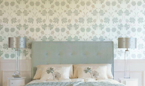 A bedroom with floral wallpaper.