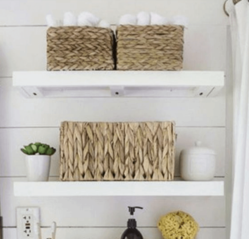 Open bathroom shelves with woven baskets.