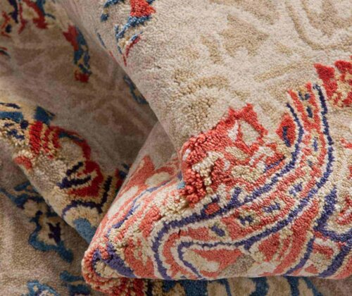 A tan rug with an orange and blue design.