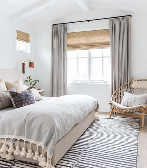 A mix of drapes and blinds in the bedroom.