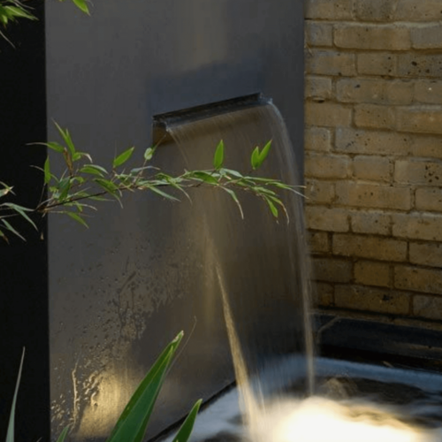 A waterfall fountain coming out of a wall.