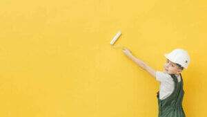 A boy painting a wall.