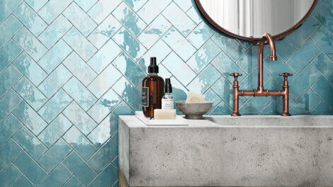 a bathroom with blue tiles on the wall with cool colors