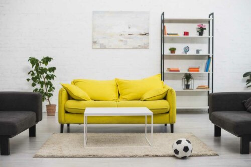 a living room with a bright yellow sofa and white walls in a second home