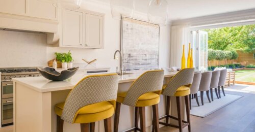 A kitchen with some chairs by Sophie Peckett.