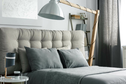 A lamp over a bed.