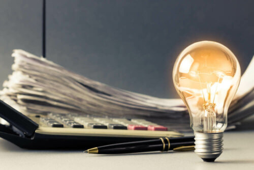 A lightbulb magically lit-up beside some papers.