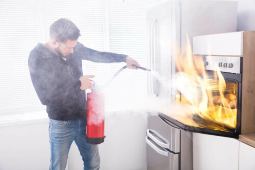 A man putting out a fire hoping he has homeowners insurance.