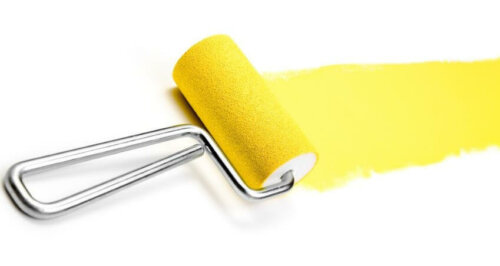 A paint roller with yellow paint.